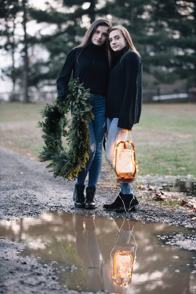 sister at dusk with lantern and christmas wreath Loudoun County mini sessions