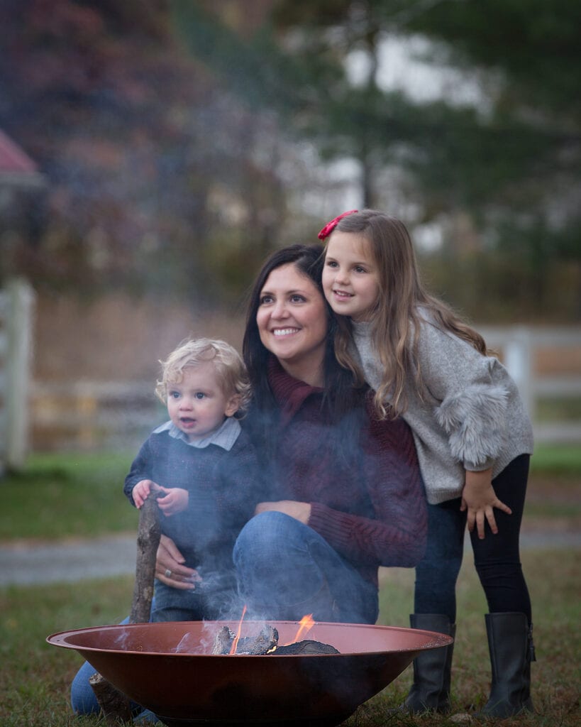 Mom and kids enjoying outside fire in autumn