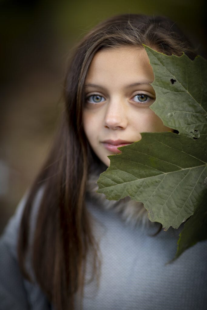 Girl with beautiful eyes and green leaf fall photo session