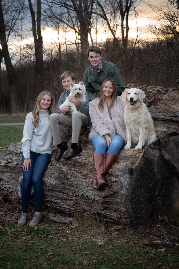 Family photo with dog on large wood pile