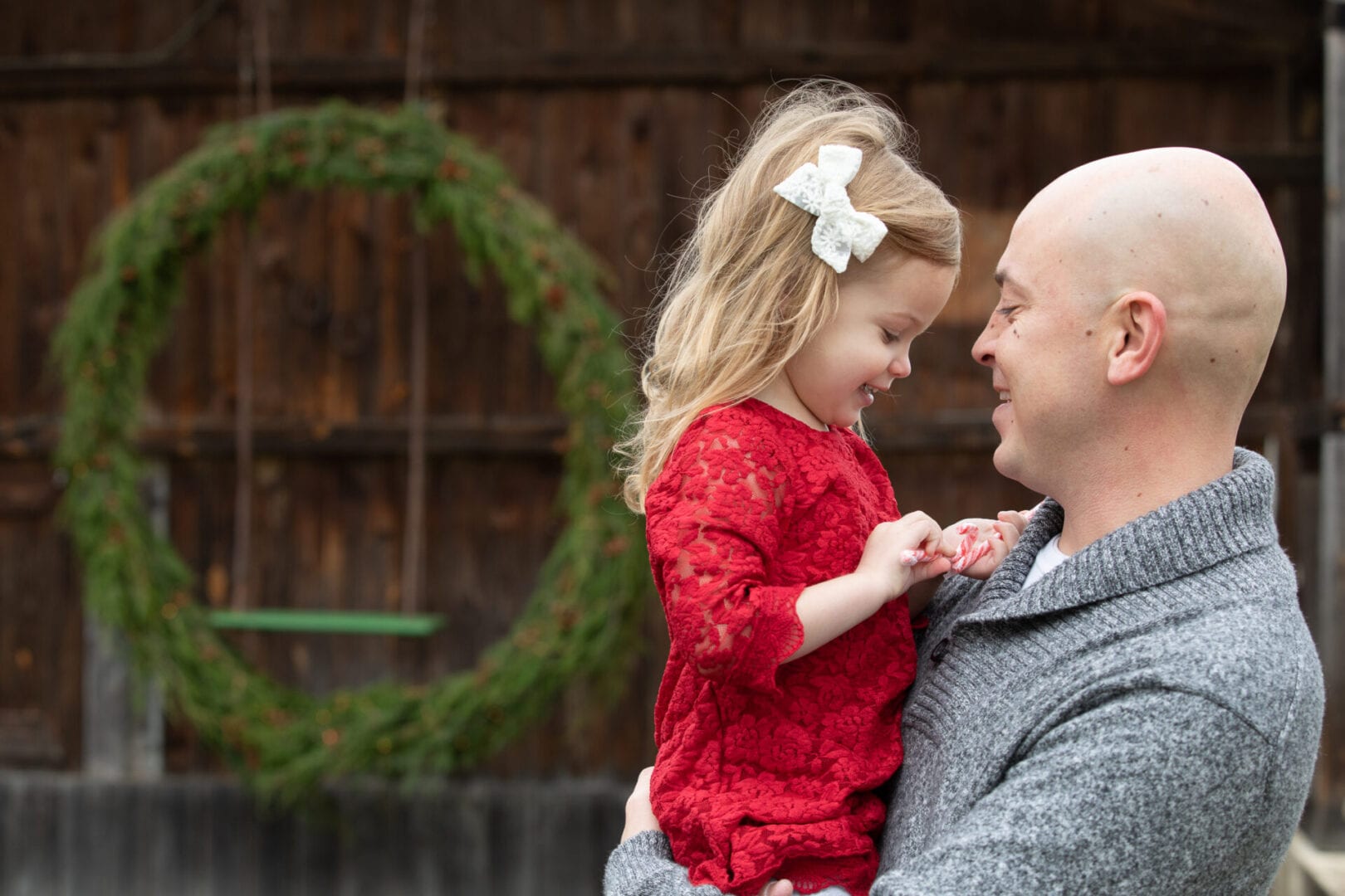 small girl in daddy's arms at christmas time