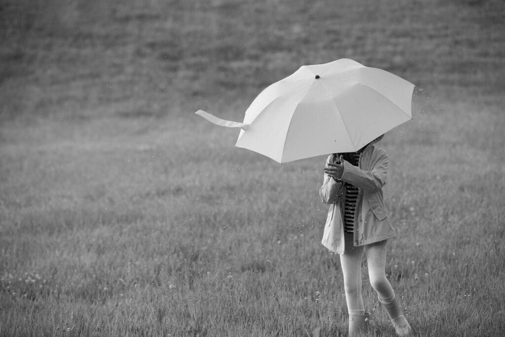 Girl in field with umbrella in a rain shower, Middleburg Virginia