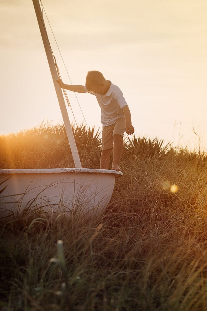 Boy on sailboat at sunset