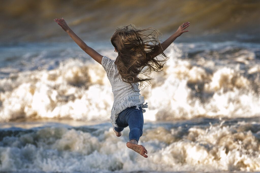 Girl dancing in Ocean waves corolla NC