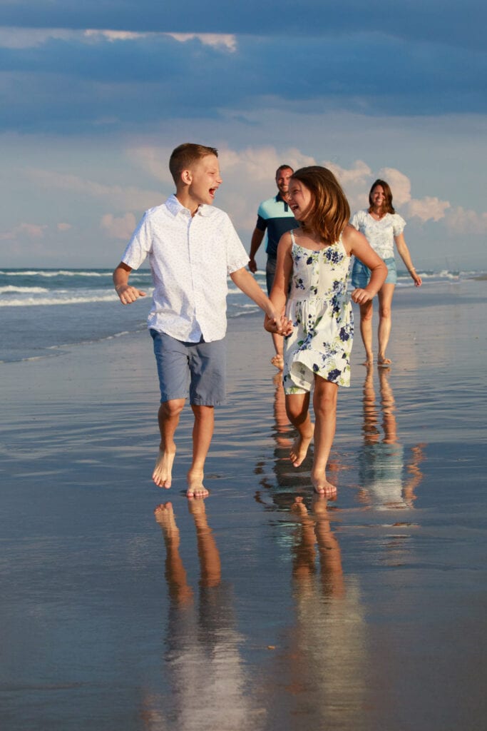 brother and sister running on the beach with reflection on the sand, Duck NC