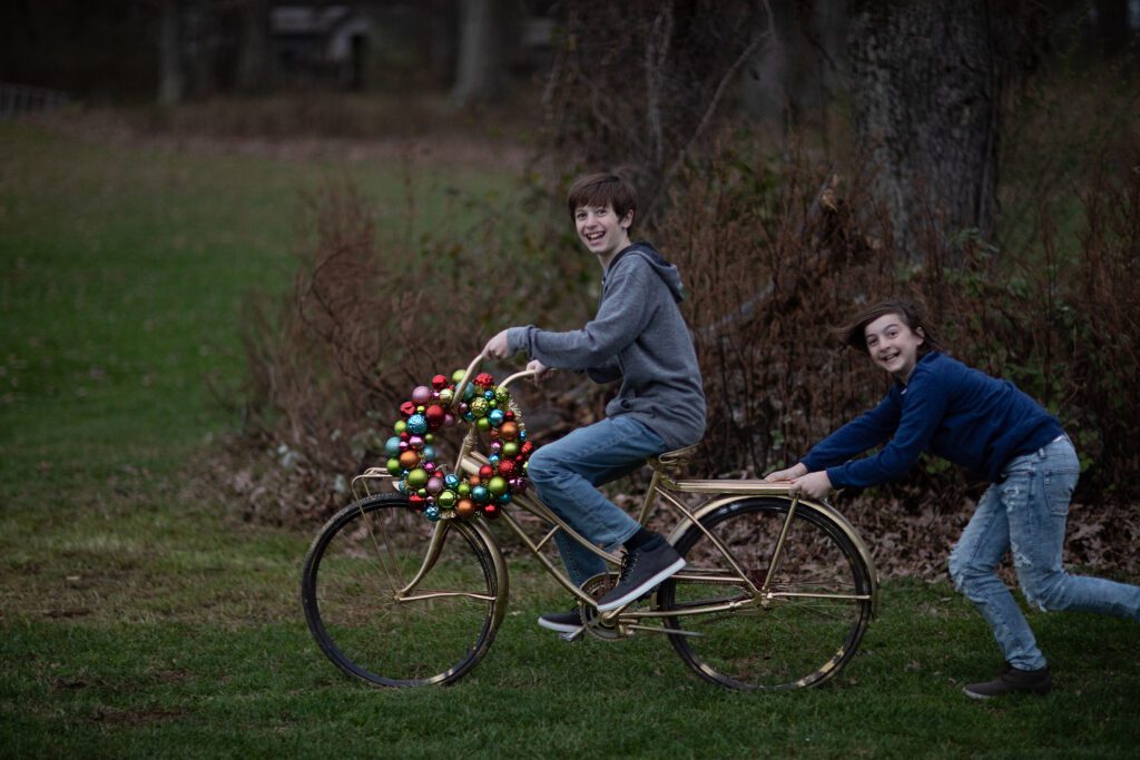 boys on tandem bike with a holiday wreath