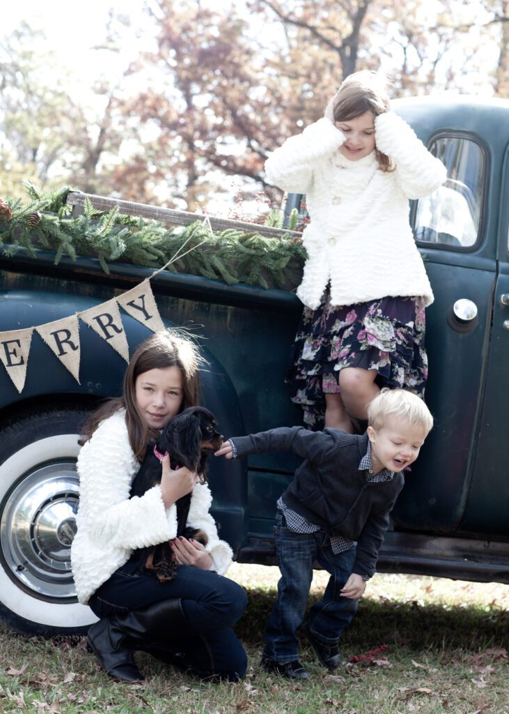 Kids by old truck with holiday theme