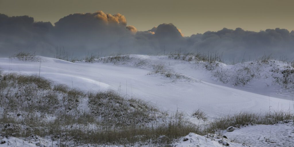 Snow covered dunes surrounded by beautiful clouds in Carova, NC