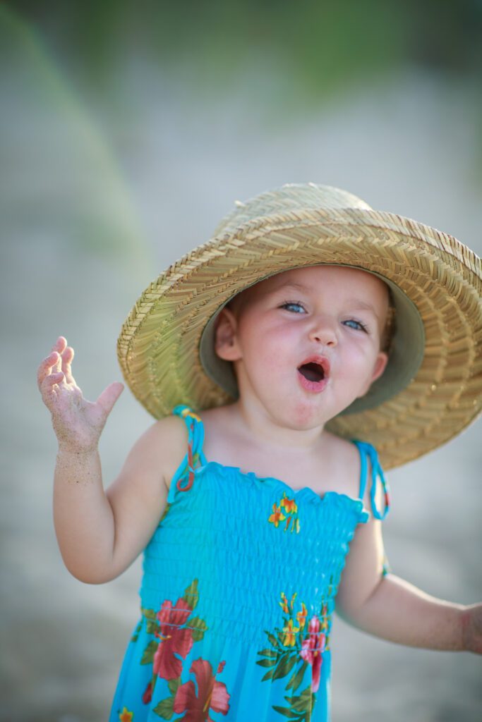 Little girl with large hat on  the beach carova NC