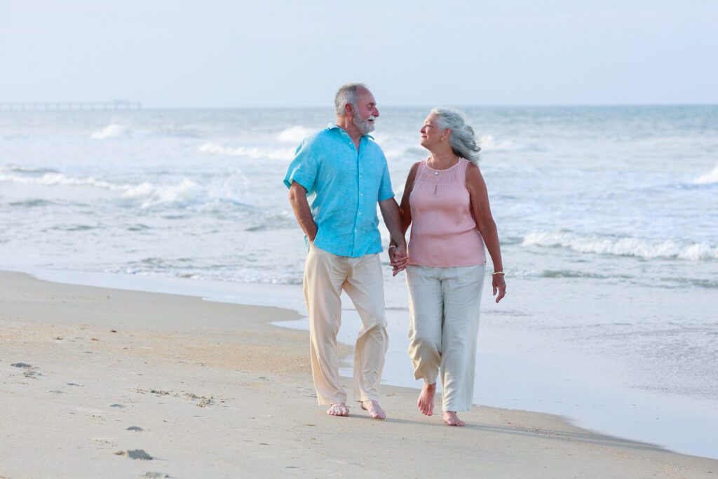 50 years of marriage, enjoying a beach walk in the golden hour along the beaches of Duck, NC