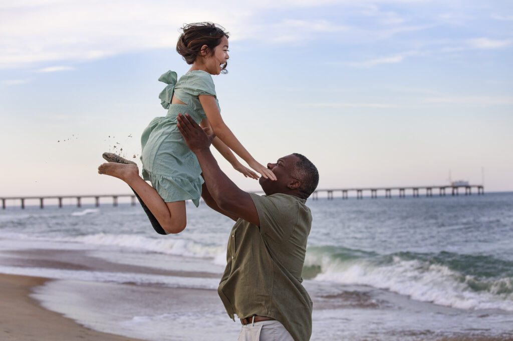 Father playing with young daughter on the beach, Duck, NC