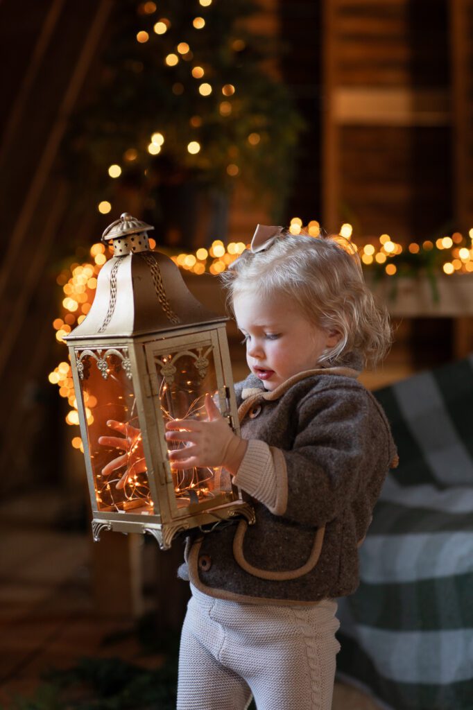small girl with lantern in old barn
