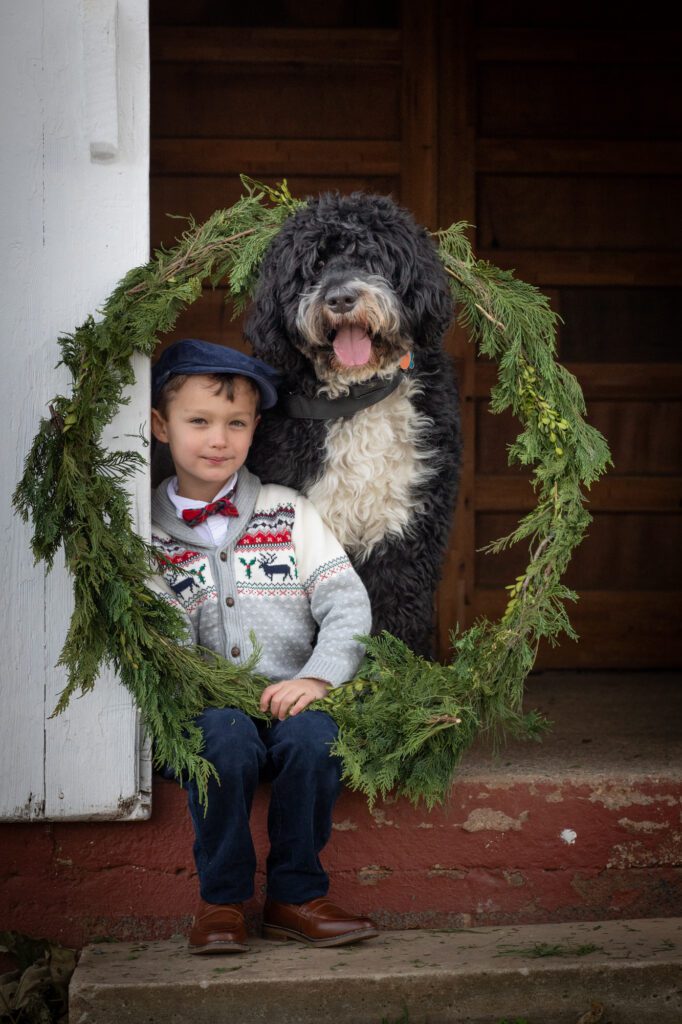 Little boy with his large dog and Christmas wreath in Waterford Virginia