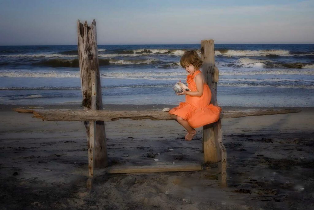 little girl in bright colored dress on drift wood in the OBX