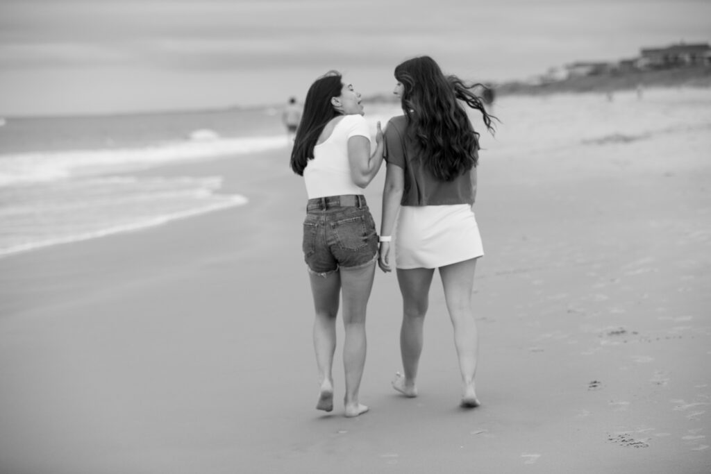 Sisters walking enjoying a laugh on the beach in Duck NC