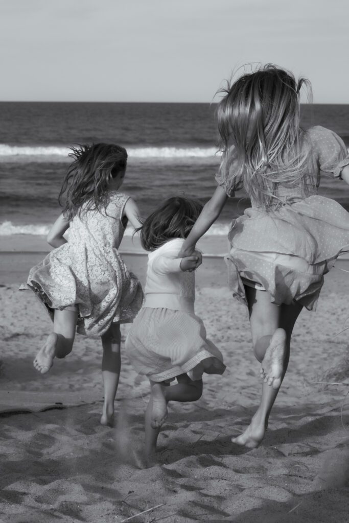 three sisters running to the beach in Duck, NC