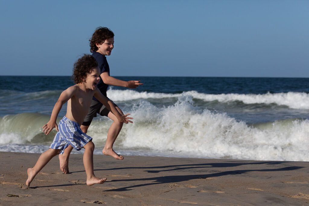 brothers running along the beach in Duck NC