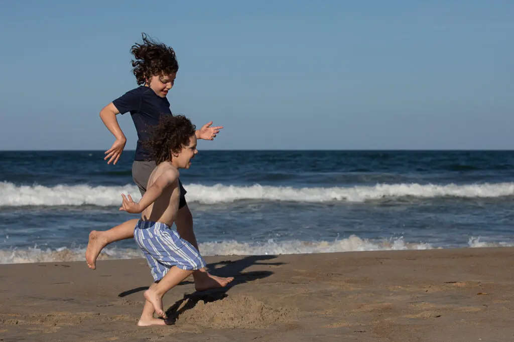 Brother running on the beach in Duck NC