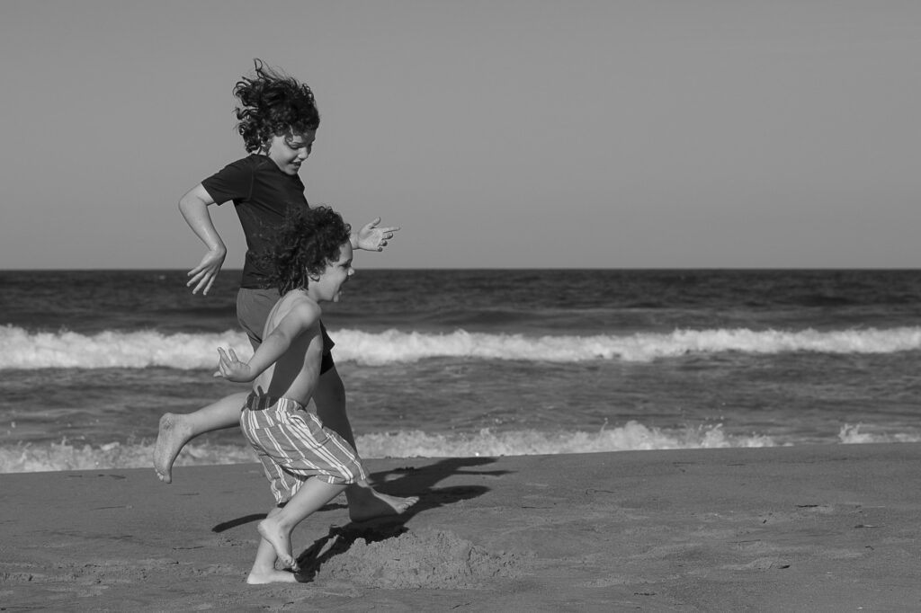 Brothers running in the surf, Duck NC