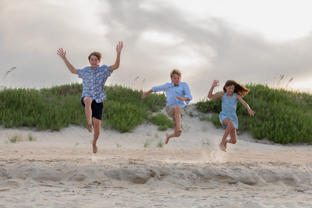 siblings jumping on the beach in Duck, NC