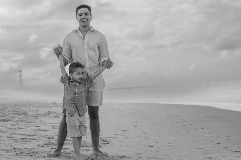 Black and white photo of brothers on the beach with beautiful storm clouds on the beaches of the OBX