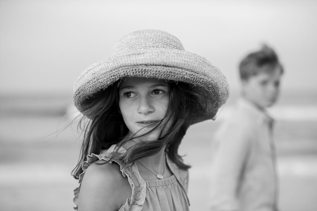 Black and White beach photo of girl with beach hat, and beautiful light in Duck, NC