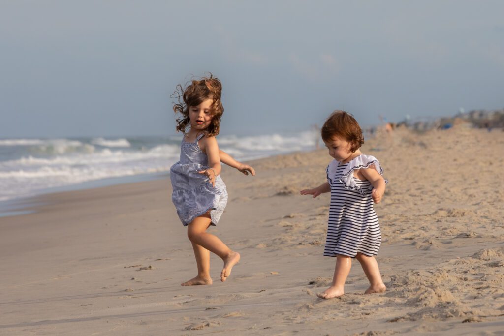Little sisters walking on the beach in Corolla, NC