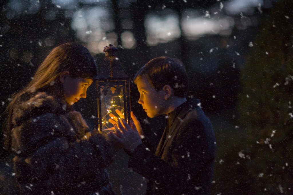 Children with a glowing lantern in the snow, a beautiful holiday setting