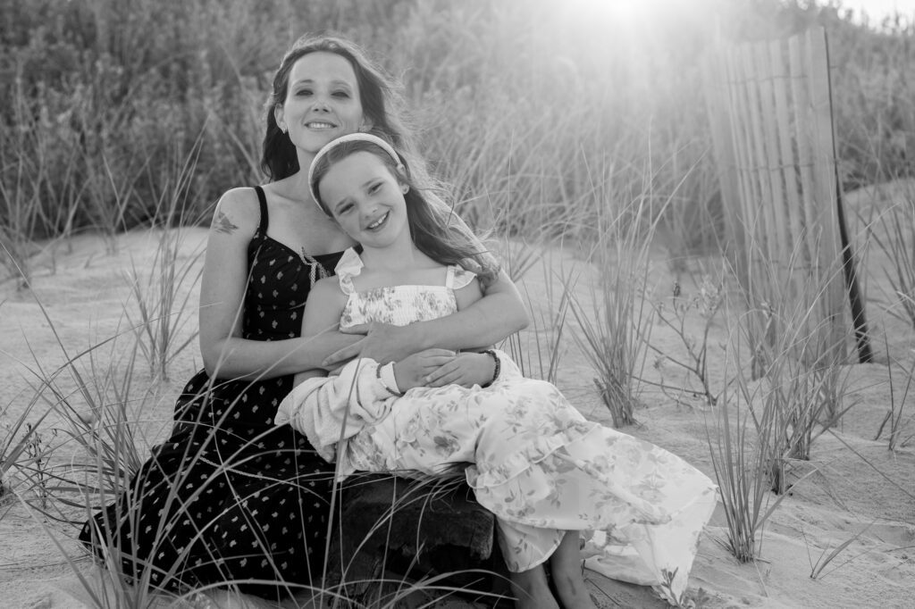 Mom and daughter in the dune in Duck, NC with beautiful sunset behind them