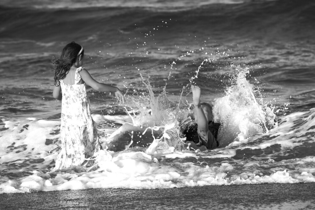 boy splashing in the ocean along the beaches of Duck, NC