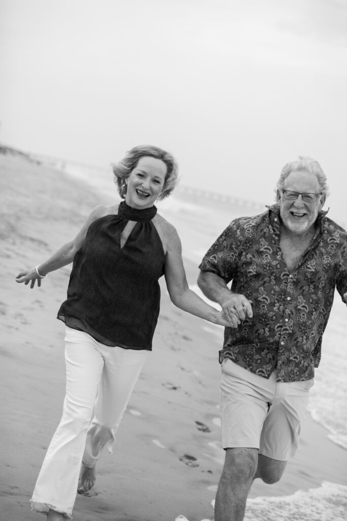 Grandparents running along the beach in Duck, NC